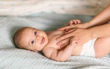 Massage for the baby. Four month old baby smiling doing gymnastics